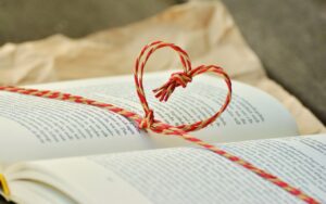 libro abierto con un corazón de cordel sobre sus páginas